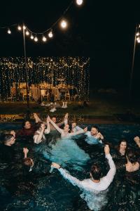 a group of people in a swimming pool at night at Poderey Villas in Yaremche +42 photos