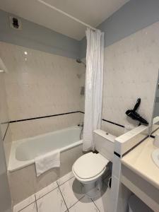 ein Badezimmer mit einem WC, einer Badewanne und einem Waschbecken in der Unterkunft Hôtel Michelet Plage in Soulac-sur-Mer