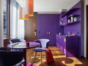 kuchnia z fioletowymi szafkami, stołem i krzesłami w obiekcie 25hours Hotel Zürich West w Zurychu