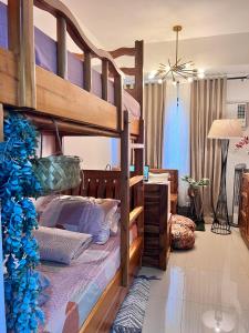 a bedroom with a bunk bed and a living room at SMDC Green 2 Staycation, The Traditional & Modern Fusion Condo in Pasong Bayog