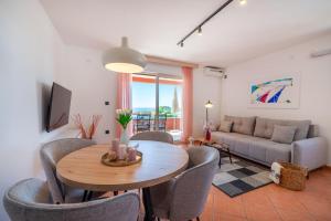 a living room with a table and chairs and a couch at Apartments Villa SanMarino in Pakoštane +85 photos