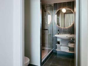 a bathroom with a sink and a mirror at Aparthotel Adagio Glasgow Central in Glasgow