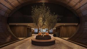 un gran vestíbulo con un árbol en el medio. en Hilton Queretaro en Querétaro