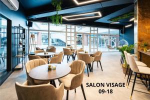 a restaurant with tables and chairs and large windows at Cosmopolitan Bobycentrum - Czech Leading Hotels in Brno