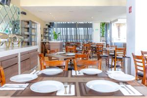 comedor con platos blancos y sillas de madera en Comfort Inn Queretaro Tecnologico en Querétaro