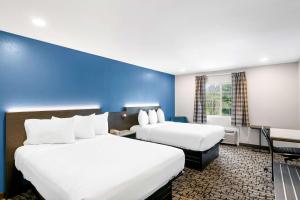 Habitación de hotel con 2 camas y pared azul en Econo Lodge Bethel - Danbury en Bethel