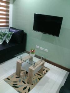- un salon avec une table basse en verre et une télévision dans l'établissement Loft Style Condo Unit in Makati with Netflix WIFI, à Manille