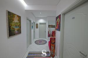a hallway with white walls and a hallway with paintings at Hotel SALA in Sarandë