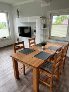 a wooden dining room table with chairs and a television at Ferienhaus Soleblick in Bad Salzungen