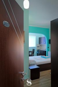 een deur naar een kamer met een bed en een keuken bij Sala's Boutique Hotel in Sarandë