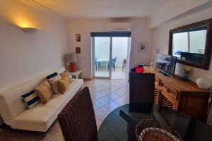 Una sala de estar con un sofá y un televisor. en Praia Oura Sunset, en Albufeira