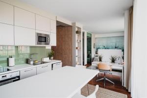 kuchnia z białymi szafkami i jadalnią w obiekcie Butique Apartman Grand w mieście Balatonlelle