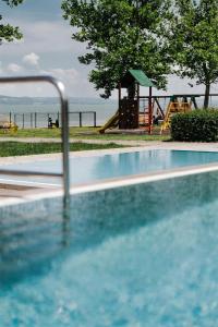 a swimming pool with a playground and a slide at Butique Apartman Grand in Balatonlelle