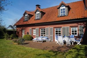 a house with a patio with chairs and a table at Ferienhaus Turm360, FeWo Vermittlung Nordsee, C Hüppeler in Varel