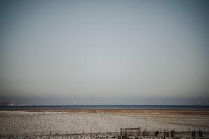 a beach with the ocean in the background at Ferienhaus Turm360, FeWo Vermittlung Nordsee, C Hüppeler in Varel +28 photos