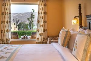 a bedroom with a bed and a window with a view at Ratan Villas Sariska in Alwar