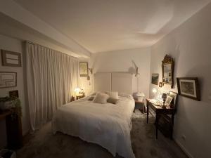 - une chambre avec un lit blanc et un bureau dans l'établissement Villa K Maison archi avec piscine 15 mn PUY du FOU, à Cholet