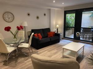 a living room with a black couch and a glass table at Apartamento Cervantes Centro Historico in Salamanca