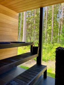 a porch of a wooden cabin with a basket on it at Mustika Mirror minivilla saunaga in Kärdla