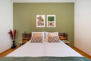 a bedroom with a white bed with three pillows at Apartments Villa SanMarino in Pakoštane