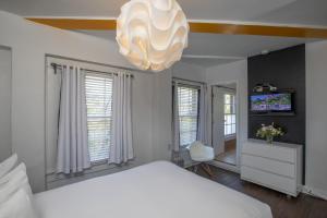ein Schlafzimmer mit einem weißen Bett und einem Kronleuchter in der Unterkunft Edwardian Hotel in San Francisco