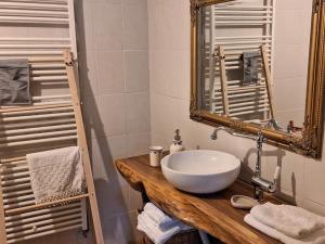 a bathroom with a white sink and a mirror at Căsuța cu Prispă in Sîncraiu