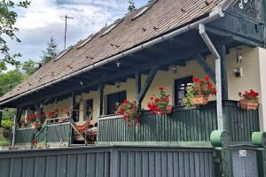 a house with flower boxes on the balcony at Căsuța cu Prispă in Sîncraiu