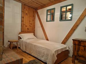a bedroom with a bed and two windows at Căsuța cu Prispă in Sîncraiu