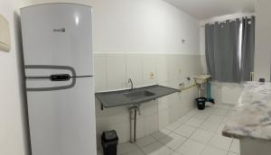 a kitchen with a sink and a refrigerator at Apartamentos da Thay in Campina Grande