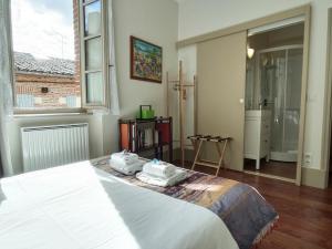 a bedroom with a bed with two towels on it at La Maison des 2 Ponts Clim Centre in Albi