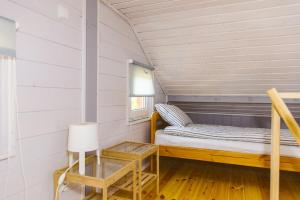 a small bedroom with a bed and a table at Surf Domki Habenda z sauną ogrodową in Sarbsk