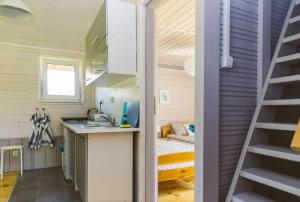 a tiny house with a kitchen and a bedroom at Surf Domki Habenda in Sarbsk
