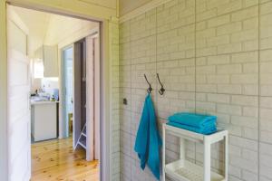 Baño con una toalla azul en la pared en Surf Domki Habenda z sauną ogrodową, en Sarbsk 26 fotos más
