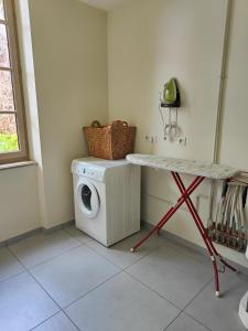 a laundry room with a washing machine and a table at La Maison des 2 Ponts Clim Centre in Albi