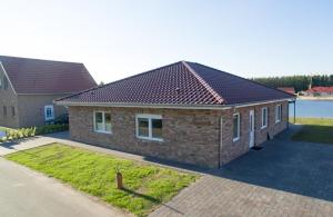 a brick house with a roof on a street at Seeufer in Walchum