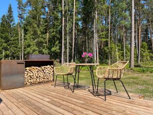 a table and chairs on a deck with a fire place at Mustika Mirror minivilla saunaga in Kärdla