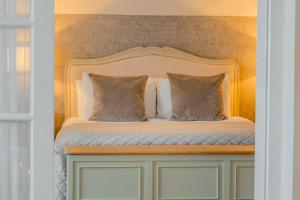 a bed with a white headboard and two pillows at Bosworth Hall Hotel & Spa in Market Bosworth +149 photos
