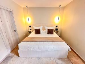 sypialnia z dużym białym łóżkiem z 2 poduszkami w obiekcie AlliOli Boutique Hotel Spa w mieście Castelló d'Empúries