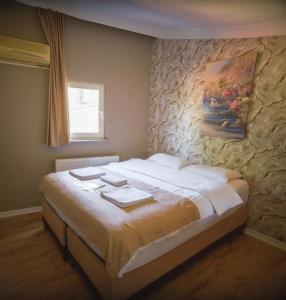 a bedroom with a large bed with a stone wall at White Palace Büyükada in Adalar