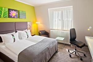 - une chambre avec un lit, un bureau et une chaise dans l'établissement Hotel Leipzig-Günthersdorf, à Kötschlitz