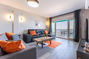 een woonkamer met een bank en een tafel bij MalagaSuite Golden Views Fuengirola in Fuengirola