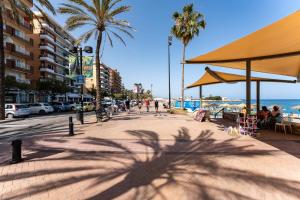 een schaduw van een palmboom op een stoep vlakbij het strand bij MalagaSuite Golden Views Fuengirola in Fuengirola