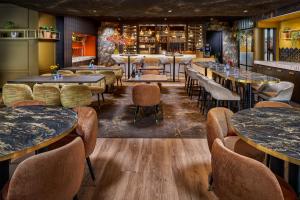 een restaurant met tafels en stoelen en een bar bij Hotel Restaurant Grandcafé 't Voorhuys in Emmeloord