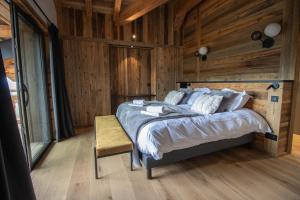 ein Schlafzimmer mit einem Bett und einer Holzwand in der Unterkunft Chalet Caly - 15pers - vue montagne in Les Gets + 42 Fotos