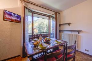 une salle à manger avec une table et une grande fenêtre dans l'établissement Il Nido di Elda few steps from skiing - Happy Rentals, à Bardonnèche