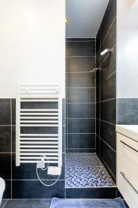 a bathroom with a shower with black tiles at Lurbe Bleue - Bordeaux central et calme in Bordeaux
