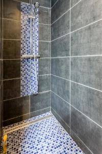 y baño con ducha de azulejos azules. en Lurbe Bleue - Bordeaux central et calme en Burdeos