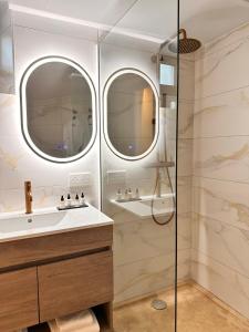 baño con lavabo y ducha con 2 espejos en AlliOli Boutique Hotel Spa en Castellón de Ampurias