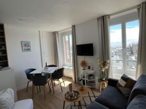 Una sala de estar con un sofá y una mesa con sillas. en Le Bellevue, en Granville 8 fotos más