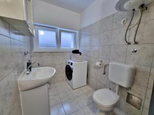 a bathroom with a white toilet and a sink at Apartment Anka in Omiš